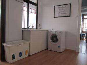 a laundry room with a washing machine and a sink at Casa Azul Hostel in Sintra
