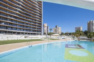 a large swimming pool in front of a tall building at Sunset Waves IV by Terreta Rentals in Benidorm