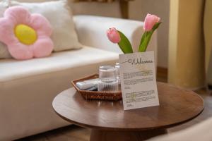 a table with a vase of pink flowers on it at Dechill House in Hanoi