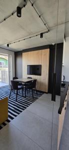 a room with a table and chairs and a television at Green Port ADMUS Apartments for Rent in Kołobrzeg