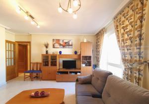 a living room with a couch and a table at Apartamentos SOL Y PLAYA Foz in Foz