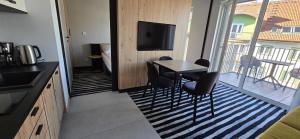 a kitchen with a table and chairs and a balcony at Green Port ADMUS Apartments for Rent in Kołobrzeg