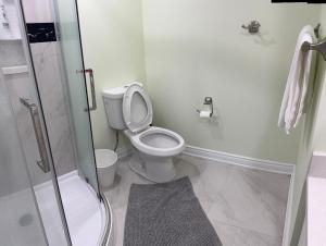 a white bathroom with a toilet and a shower at B2 Cozy room by Mendy in Mississauga