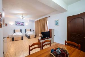 a living room with a couch and a tv in a room at Cozy Apartments Downtown in Ksamil