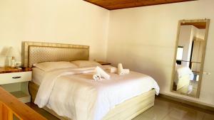 a bedroom with a large bed with a mirror at Rida Village Ksamil Island in Ksamil