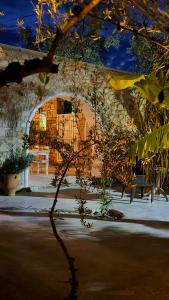 a building with an archway with a table and benches at Rida Village Ksamil Island in Ksamil