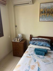 a bedroom with a bed and a dresser and a painting at Tranquil paradise in Larnaca