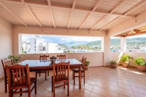 a dining room with a table and chairs and a large window at Cozy Apartments Downtown in Ksamil