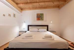 a bedroom with a large white bed with two pillows at Cozy Apartments Downtown in Ksamil