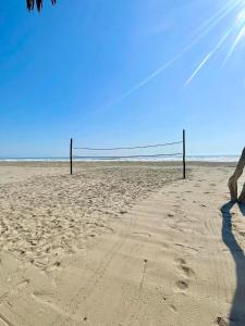 a person standing on a beach with a volleyball net at Bungalows en playa Wakama in San Vicente de Cañete +1 photo