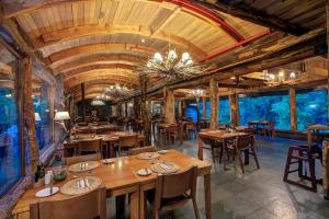 una sala da pranzo con tavoli e sedie in legno di Huilo Huilo Reino Fungi a Huilo Huilo