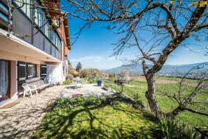 a house with a bench and a tree at Les Hortensias in Reignier
