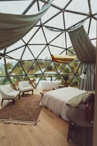 a room with a bed and a tub in a glass house at KUUL STAY - luxury domes in Virtsu