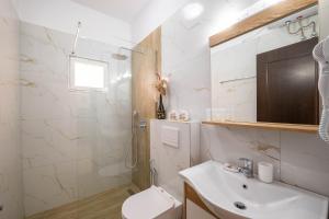 a white bathroom with a sink and a toilet at Cozy Apartments Downtown in Ksamil +160 photos