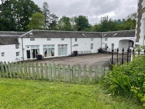 a white building with a fence in front of it at 3 Telford Mews in Dumfries