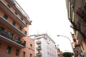 un edificio blanco alto en una calle de la ciudad con edificios en The Green Corner, en Roma