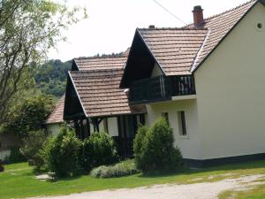 una casa con un balcón en el lateral. en Panzió-Kemping Bekölce en Bekölce