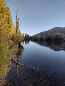 a river with trees on the side of it at El Quillango in Villa Llanquin