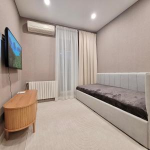 una piccola stanza con un letto e un tavolo di ApartPoltava Premium Relax двокімнатні апартаменти з ДЖАКУЗІ a Poltava