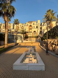 a fountain in a park with palm trees and buildings at Spectacular Flat Vera Playa in Playas de Vera
