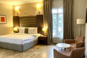 a hotel room with a bed and a chair at The Sojourner By Genesis in Ikeja