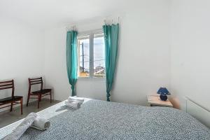 1 dormitorio con 1 cama y una ventana con cortinas verdes en Spacious cocoon in Narbonne - with sea view, en Narbona