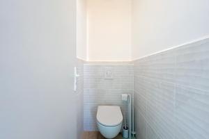 Un baño con un inodoro blanco en una habitación. en Spacious cocoon in Narbonne - with sea view, en Narbona