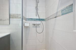 Baño blanco con ducha con puerta de cristal en Spacious cocoon in Narbonne - with sea view, en Narbona