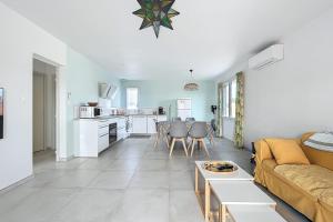 Una sala de estar con un sofá amarillo y una cocina. en Spacious cocoon in Narbonne - with sea view, en Narbona 3 fotos más