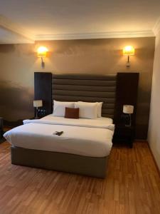 a hotel room with a large bed with two lamps at The Sojourner By Genesis in Ikeja