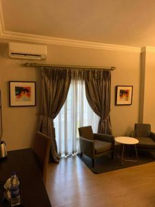 a living room with a couch and a chair and a table at The Sojourner By Genesis in Ikeja
