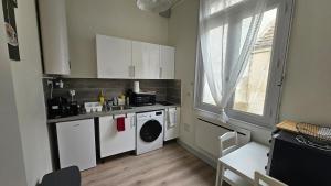 a kitchen with a sink and a washing machine at Le petit bastion - T2 - Wi-Fi in Montluçon