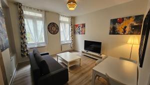 a living room with a couch and a tv at Le petit bastion - T2 - Wi-Fi in Montluçon