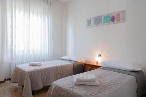 Un dormitorio con dos camas y una mesa y una ventana. en COMO LAKE VIEW Jasmin's Family House, en Musso