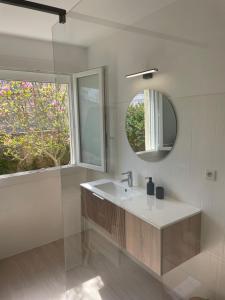 a bathroom with a sink and a mirror at Maison au calme rénovée plain-pied, hyper centre ville Perros in Perros-Guirec