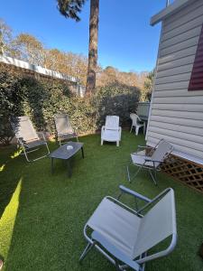 eine Gruppe von Stühlen und Stühlen auf einem Hof in der Unterkunft Mobilhome Calme 6 Personnes Camping Pierre Couché in Saint-Brevin-les-Pins