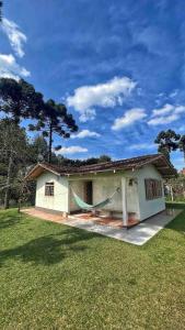 ein Haus mit einer Hängematte davor in der Unterkunft Casa de Campo, Pet friendly em Campo Alegre-SC in Campo Alegre