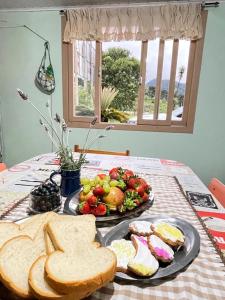 a table with a plate of bread and a plate of food at Casa de Campo, Pet friendly em Campo Alegre-SC in Campo Alegre +21 photos