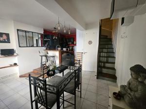 een keuken en eetkamer met een tafel en stoelen bij "Studio Cinéma" -Coeur de ville- Spacieux, calme et connecté-alexa, wifi, free, netflix, disney, prime video, jeux vidéo et de société in Auxerre