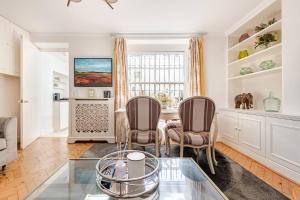 a living room with two chairs and a glass table at Secluded Modern Private Apartment by Buckingham Palace in London