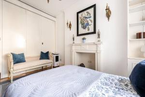a white bedroom with a bed and a fireplace at Secluded Modern Private Apartment by Buckingham Palace in London