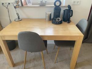 a wooden desk with two chairs and a coffee maker at Wohnen in der alten Max Selbmann Villa in Hohenstein-Ernstthal