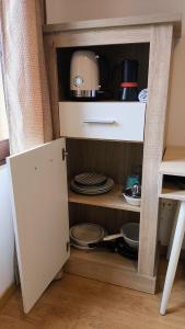 a cupboard with plates and dishes in a kitchen at Estudio Las Rotas in Denia +13 photos