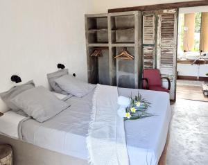 een slaapkamer met een wit bed met bloemen erop bij Villa Rose Barth Chambre in Saint-Louis