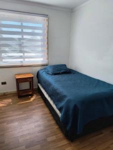 a bedroom with a bed and a table and a window at Casa de Campo a 15 minutos de Villarrica in Catrico