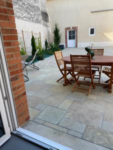 a patio with a wooden table and chairs at Maison Marguerite in Chouilly