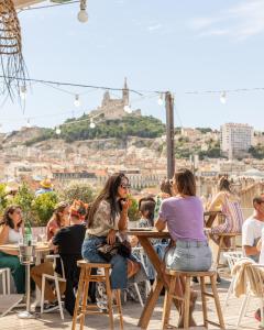 a group of people sitting at a table in a restaurant at The Babel Community Hôtel - Vieux Port in Marseille