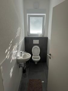 a small bathroom with a toilet and a sink at Bifi 55 in Aalen
