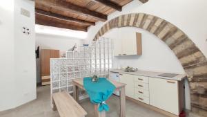 a kitchen with a table and an archway at Dietro l'Angolo in Nettuno
