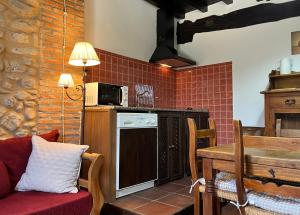 a living room with a table and a kitchen at La Cuestecilla in Hervás